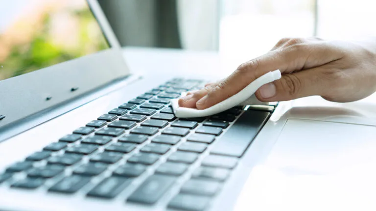 Woman using Wabi-Sabi baby wet wipes to clean keyboard